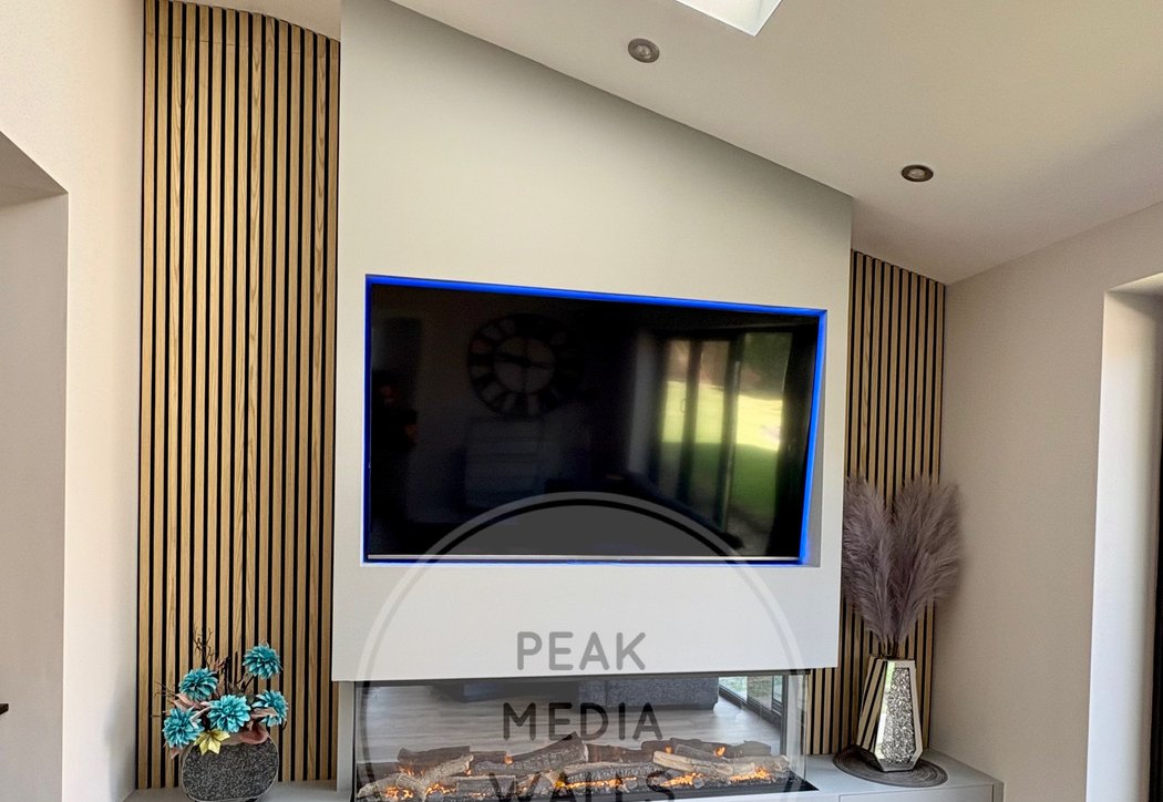 Media wall with oak slat panelling, LED backlighting and inset fire by Peak Media Walls